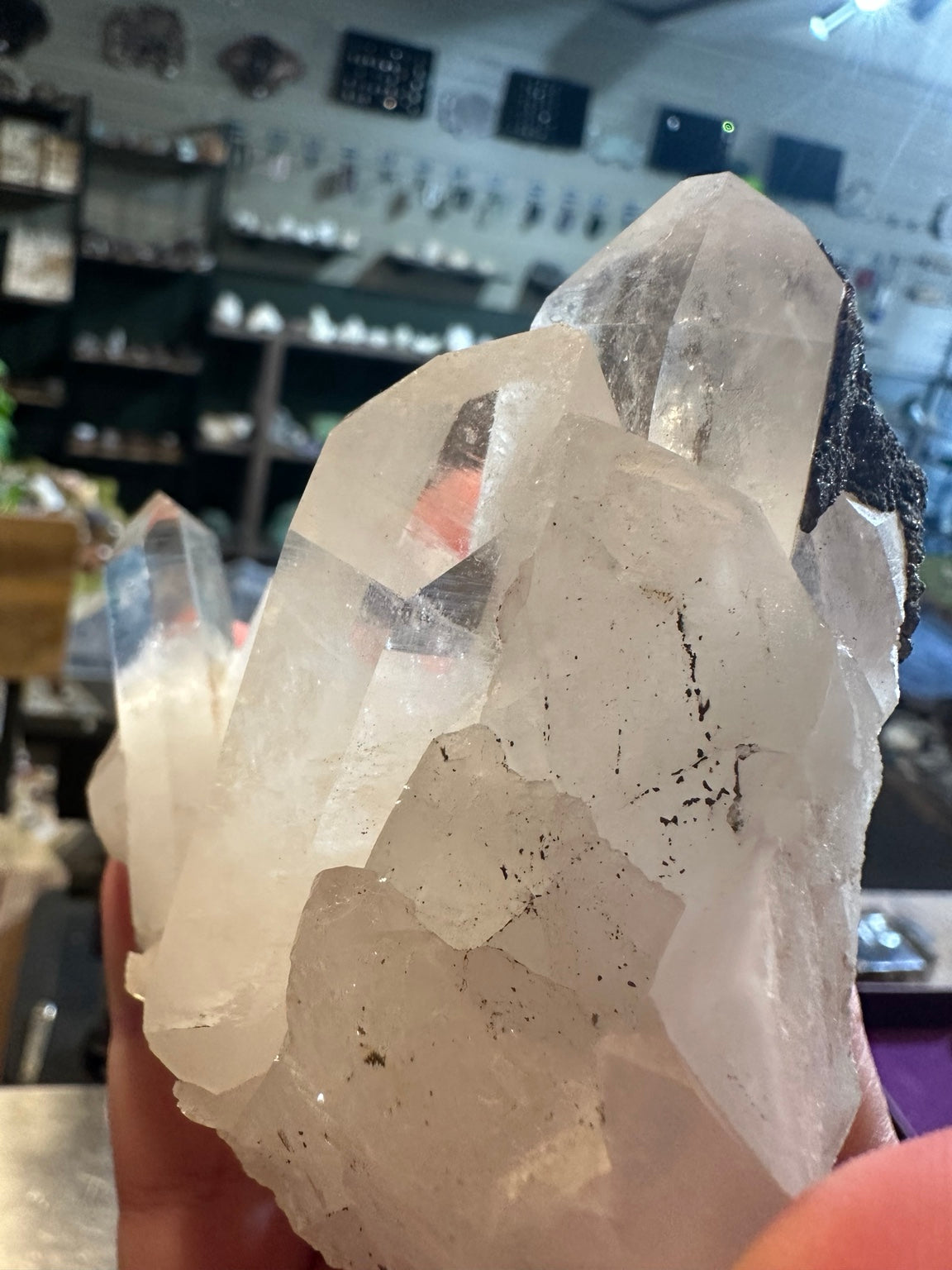 Clear quartz crystal cluster, dark mineral detail