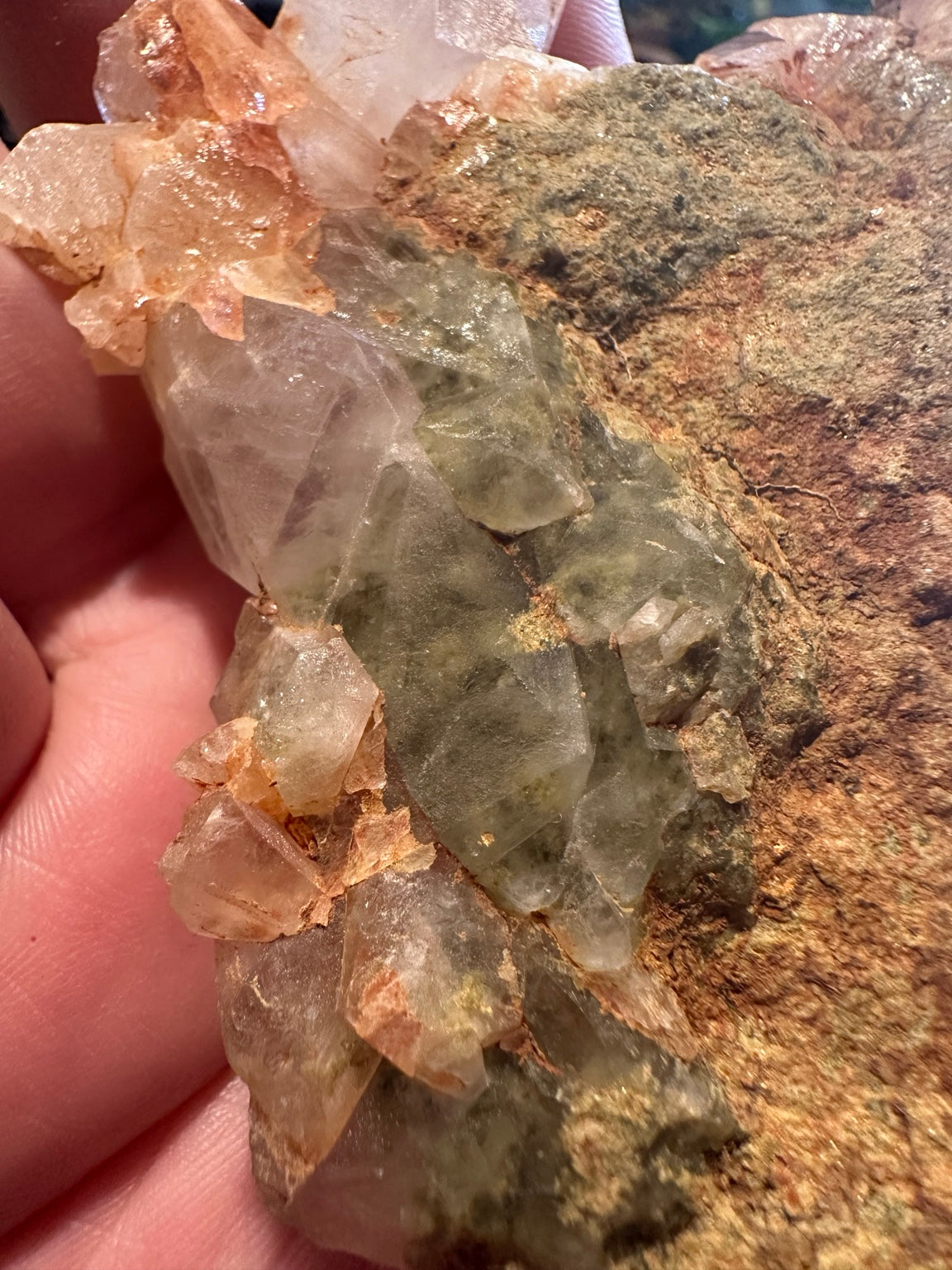 Back view showing natural rust-brown mineralized matrix and green gray crystals