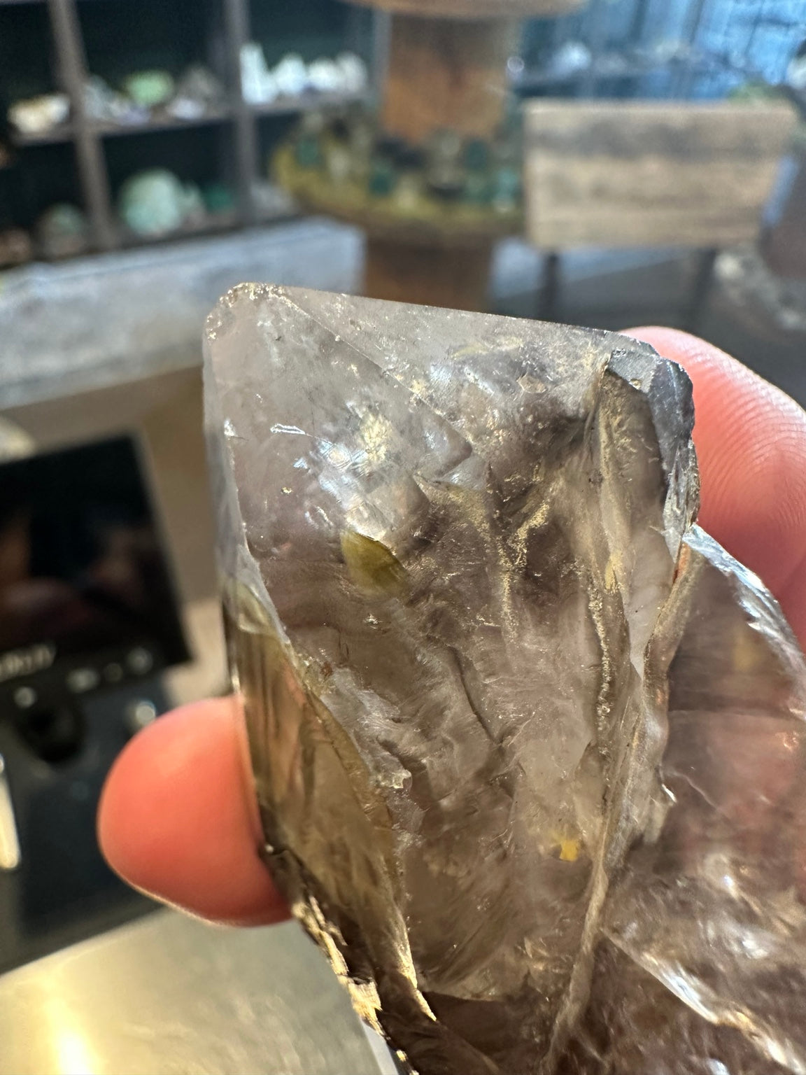 Smoky quartz crystal tip reflecting small rainbow flashes inside the crystal
