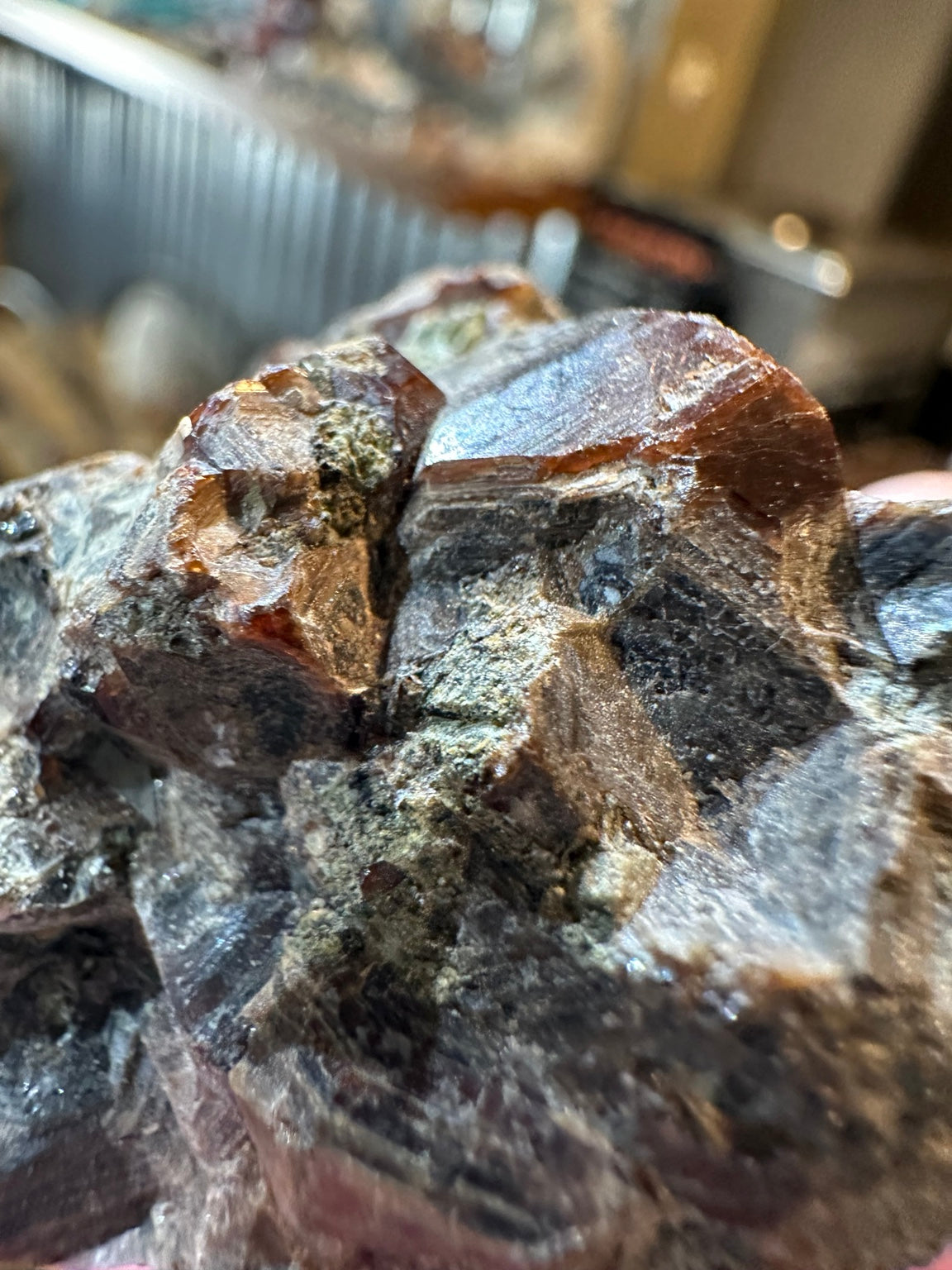 Close view of dark red-brown almandine garnet crystal faces in matrix