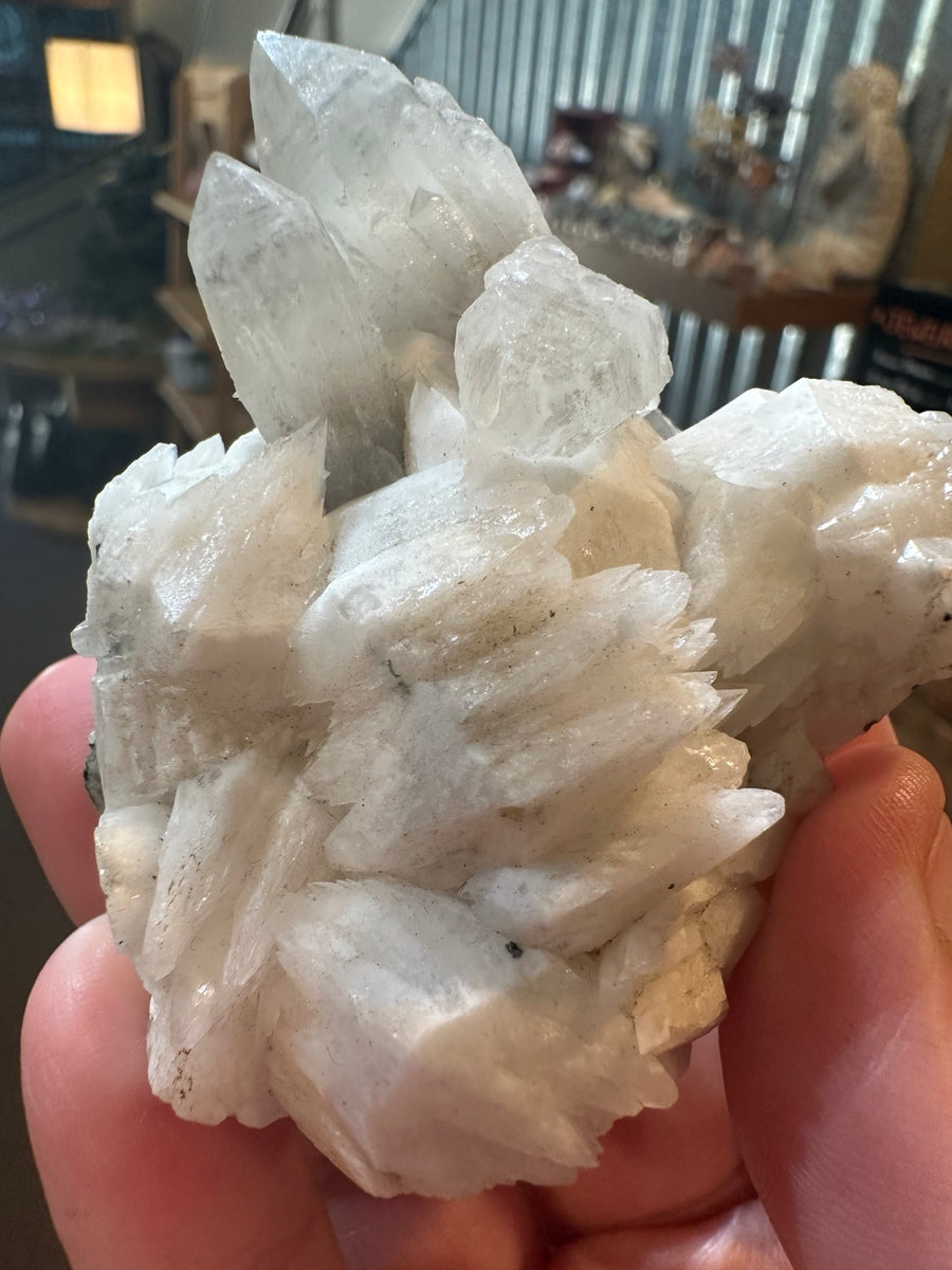 Brazilian quartz crystal cluster with white bladed crystal growth and green mineralization — view 1